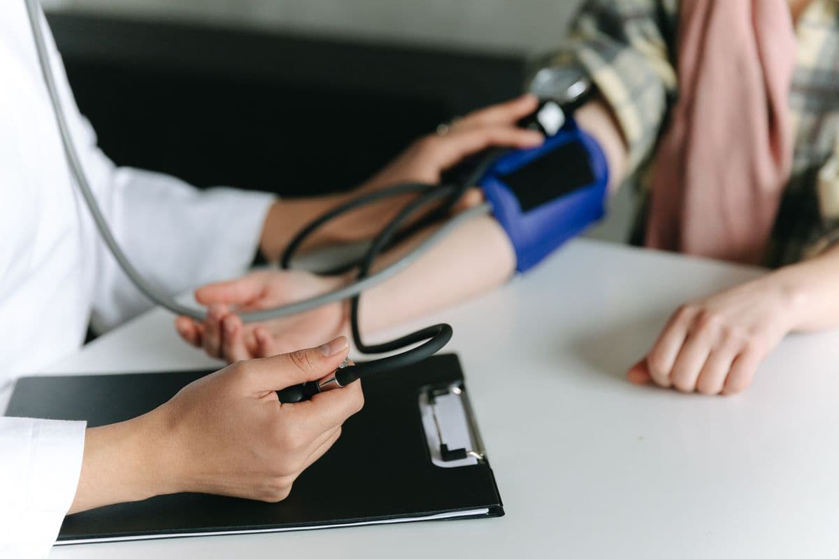 A nurse taking a patient's blood pressure at a table