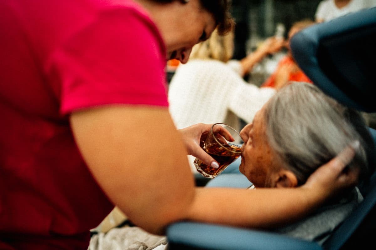 A nurse sitting with a patient in their living room